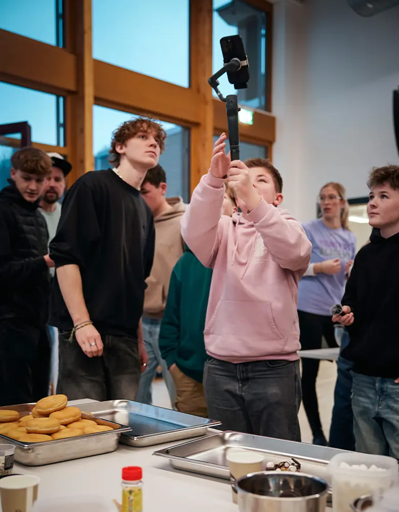 Jugendliche filmen und fotografieren gemeinsam beim Kochen